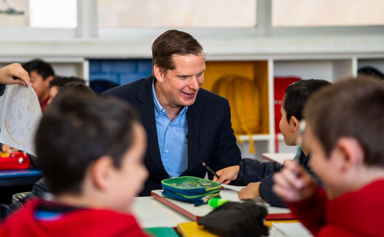 Profesor platicando con un niño en un aula de Primara del Colegio Álamos