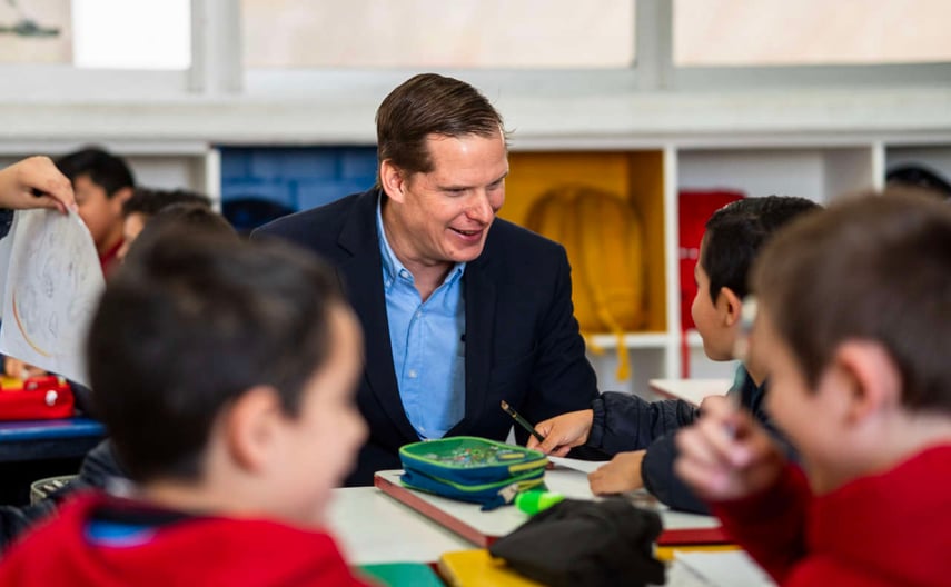 Profesor platicando con un niño en un aula de Primara del Colegio Álamos