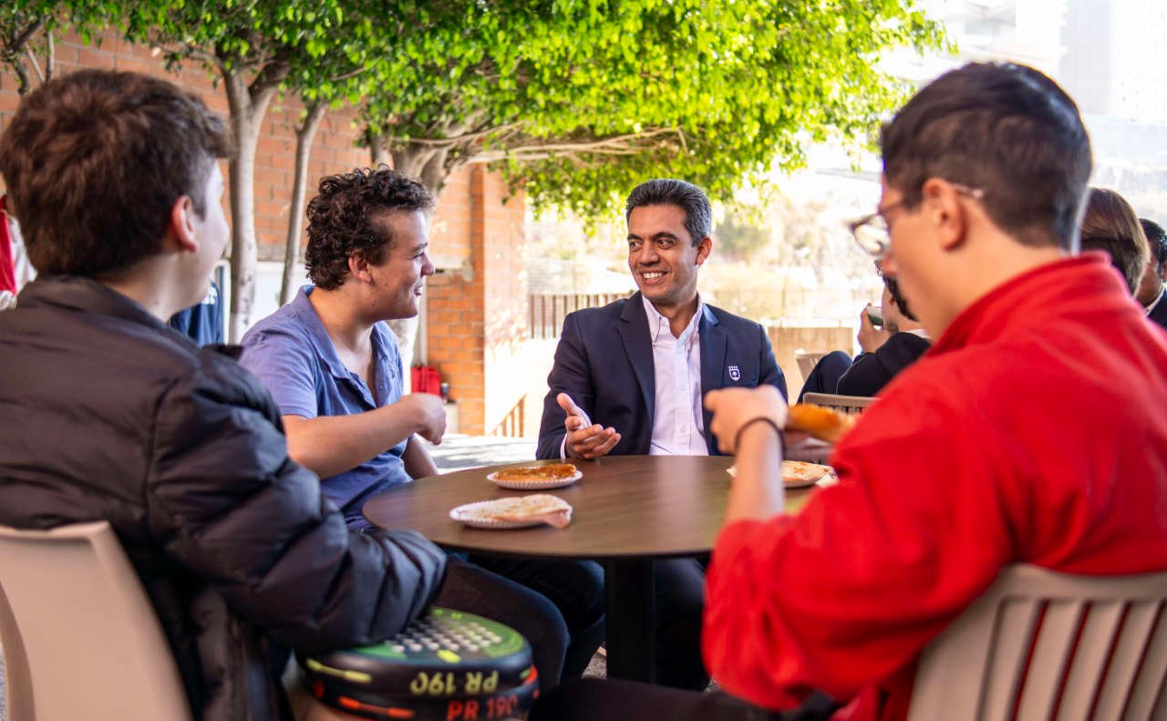 Alumnos de preparatoria platicando y compartiendo mesa con el Director del Colegio Álamos