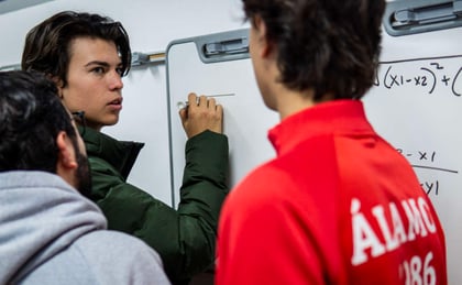 Jovenes de preparatoria realizando cálculos matemáticos  en una pizarra