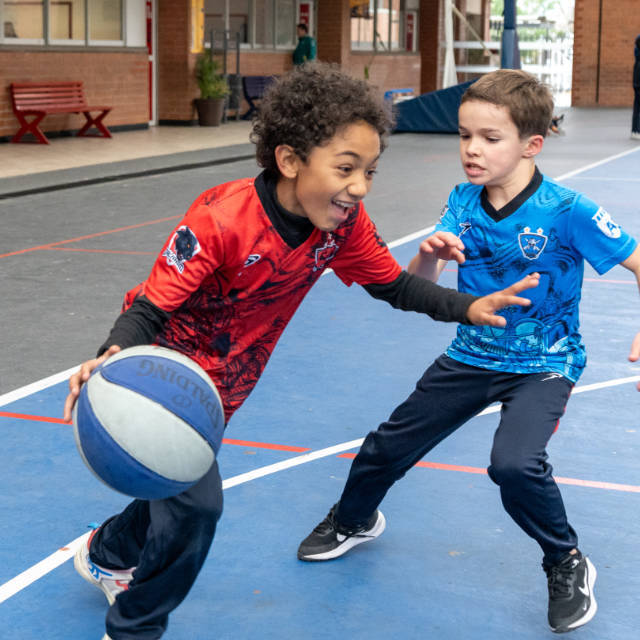 Niños jugando básquetbol en la cancha del Álamos