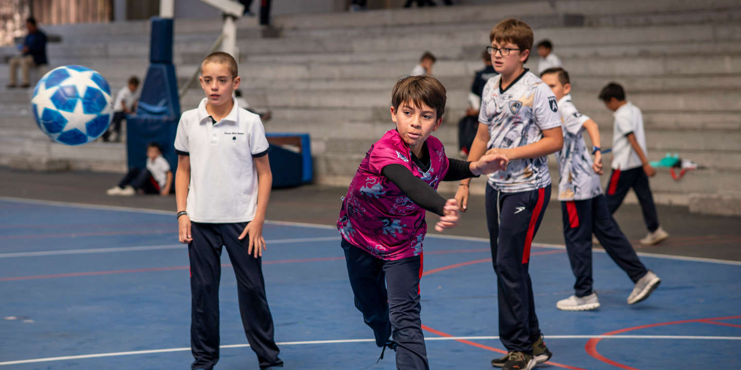 Niños de Elementary jugando quemados en la cancha Colegio Álamos