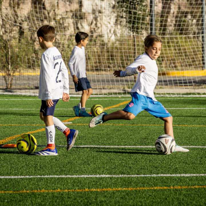 Niños en clase extraescolar de fútbol en la cancha del Colegio Álamos
