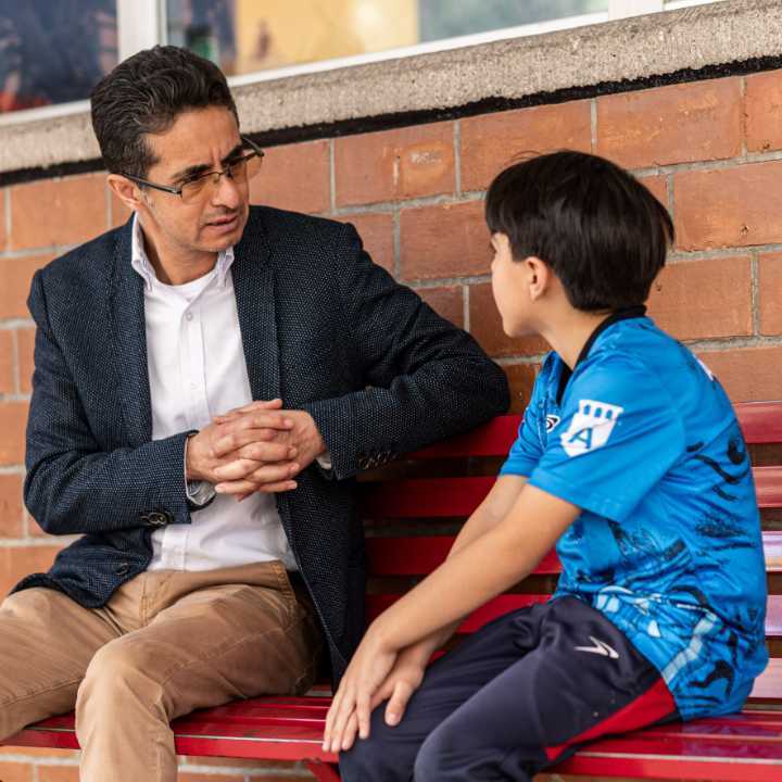 Profesor escuchando atentamente a un alumno de la primaria  Álamos