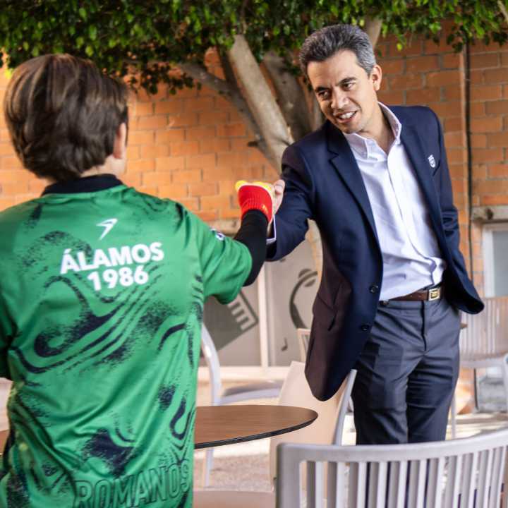 Alumno de secundaria saludando al director del Colegio Alamos